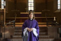 Portrait of priest in purple robes in church, selective focus — Stock Photo
