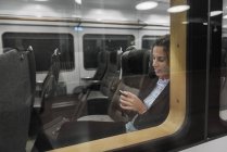 Женщина, использующая смартфон в поезде — стоковое фото