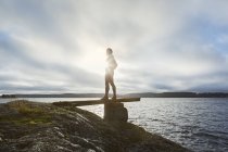 Молода жінка стоїть біля озера — стокове фото
