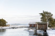 Ripostiglio barche sulla neve lungo il fiume, focus selettivo — Foto stock