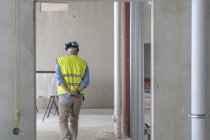 Construction worker in incomplete building, rear view — Stock Photo