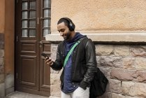 Молодий чоловік слухає музику на вулиці — стокове фото