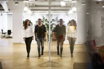 Coworkers parlare e camminare di finestra in ufficio — Foto stock