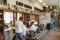 Barberes corte os cabelos dos clientes, foco seletivo — Fotografia de Stock