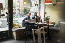 Молоді чоловіки працюють разом у кафе, вибірковий фокус — стокове фото