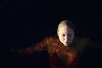 Женщина, плавающая на озере с закрытыми глазами — стоковое фото