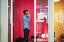 Giovane uomo che parla al telefono in ufficio — Foto stock
