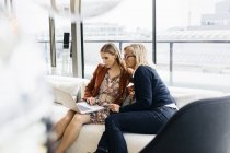 Las mujeres de negocios que utilizan el ordenador portátil, se centran en primer plano - foto de stock
