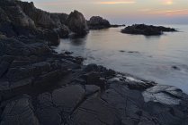 Rocas por mar al atardecer en Kullen, Suecia - foto de stock