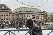 Couple using smart phone on ice rink, selective focus — Stock Photo