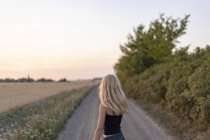 Adolescente debout sur la route rurale — Photo de stock