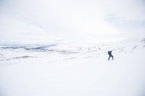 Чоловік перетинає кантрі на лижах у красивих засніжених горах — стокове фото