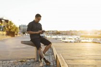 Mann benutzte Smartphone auf Uferpromenade — Stockfoto