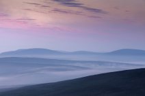 Silhouettes of hills at sunset in Scousburgh, Scotland — Stock Photo