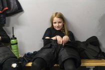 Menina em vestiário se preparando para treinamento de hóquei no gelo — Fotografia de Stock