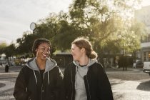 Девочки-подростки улыбаются и ходят по улице — стоковое фото