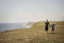Hombre y niño en la colina cerca del mar - foto de stock