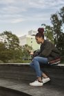 Вид сбоку красивой девочки-подростка с помощью смартфона в парке — стоковое фото