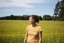 Woman standing by field in countryside in Dalarna, Sweden — Stock Photo