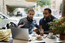 Young men working together in cafe, selective focus — Photo de stock