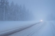 Headlights on snow covered road — Stock Photo