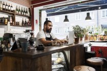 Mittlerer erwachsener Mann arbeitet im Café — Stockfoto