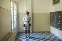 Maler steht an Briefkästen und schaut in Mehrfamilienhaus zur Seite — Stockfoto