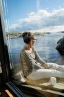 Зріла жінка сидить на балконі над морем, вибірковий фокус — стокове фото