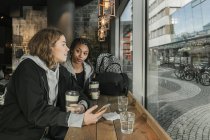 Teenage girl using smart phone in cafe — Stock Photo