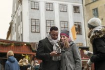Paar schaut auf Smartphone im Markt, selektiver Fokus — Stockfoto