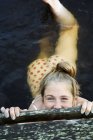 Vista ad alto angolo di felice bella ragazza adolescente nuotare in mare e sorridere di macchina fotografica — Foto stock