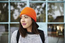Junge Frau mit orangefarbener Mütze, selektiver Fokus — Stockfoto