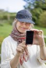 Mulher adulta média usando telefone inteligente — Fotografia de Stock