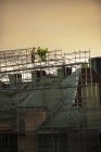 Construction workers on scaffolding at sunset — Stock Photo