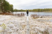 Mujer madura de pie frente al lago Lillskiren en Suecia - foto de stock