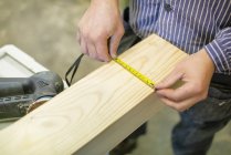 High angle view of carpenter measuring timber — Stock Photo