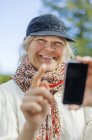 Mulher adulta média usando telefone inteligente — Fotografia de Stock