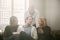 Coworkers guardando smart phone e parlando — Foto stock