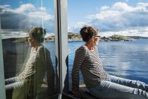 Donna matura seduta sul balcone sul mare, focus selettivo — Foto stock