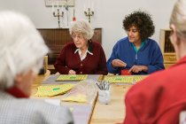 Mujeres mayores jugando bingo en casa de descanso - foto de stock