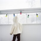 Вид сзади на ребенка в теплой одежде в помещении — стоковое фото