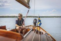 Femme adulte moyenne naviguant sur son yacht — Photo de stock
