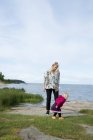 Jeune femme avec une fille par lac — Photo de stock