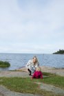 Mujer joven con hija por lago - foto de stock