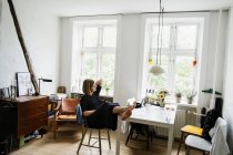 Jeune femme assise les pieds dans un appartement — Photo de stock