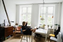 Young woman sitting with feet up in apartment — Stock Photo