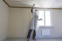 Зріла жінка ремонтує будинок, вибірковий фокус — стокове фото