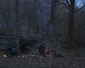 Men camping in forest at night — Stock Photo
