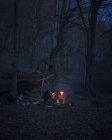 Gli uomini in campeggio nella foresta di notte, focus selettivo — Foto stock