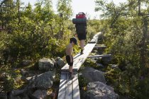 Mutter und Sohn wandern auf Holzbrücke im Fulufjallet Nationalpark, Schweden — Stockfoto